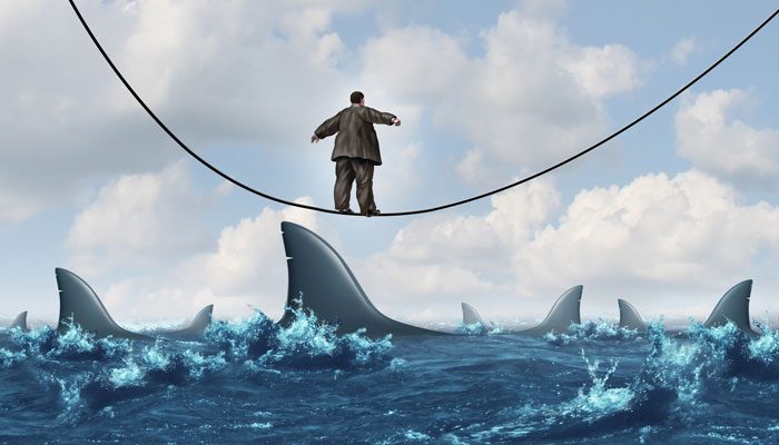 man-walking-tightrope-over-sharks.jpg